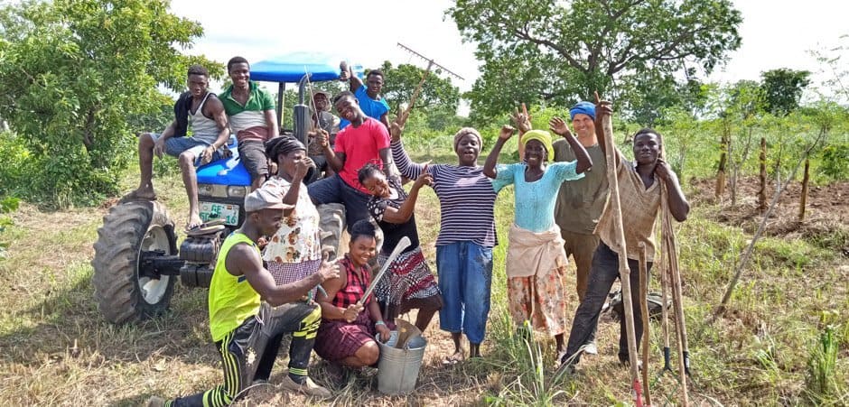 Project Introduction: Planting Trees in Ghana. Local people smile on tree farms with machinery